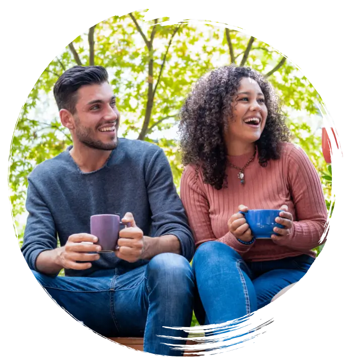 People laughing while holding coffee mugs.